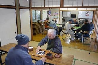 民家の中で麻雀や囲碁を楽しむ人たちの写真