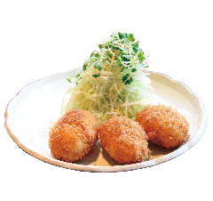 白い皿の上に野菜と一緒に盛りつけられた丹那のカニクリームコロッケの写真