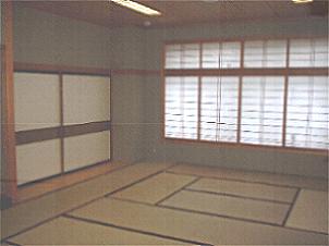 奥に障子とふすまがあり10畳のたたみが敷かれている和室の写真
