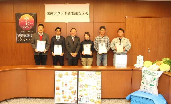 函南ブランド認定証授与式で楯を受け取り並ぶ人々の写真