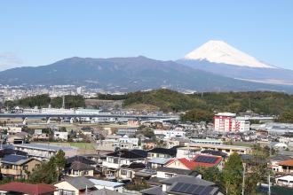 富士山を背景に住宅の中を通る東駿河湾環状道路の写真