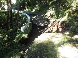 土砂崩れによって陥没し、アスファルトが流されてしまっている道路の写真