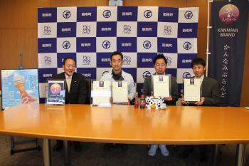 認定証を持って並んで座る男性達の写真