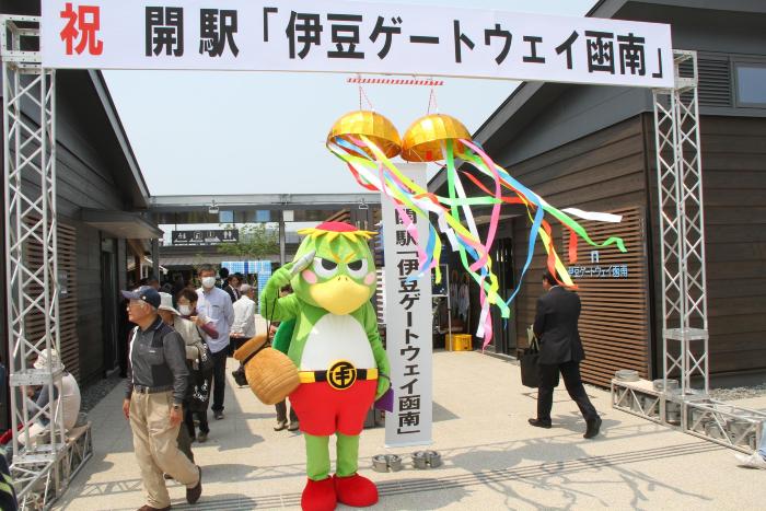 伊豆ゲートウェイ函南のくす玉の下で敬礼する河童のマスコットの写真