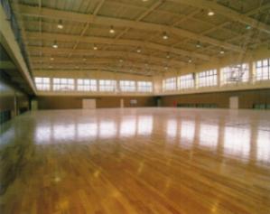 窓から日が差し込み木目の床に反射し広々とした体育館のような一階フロアの写真